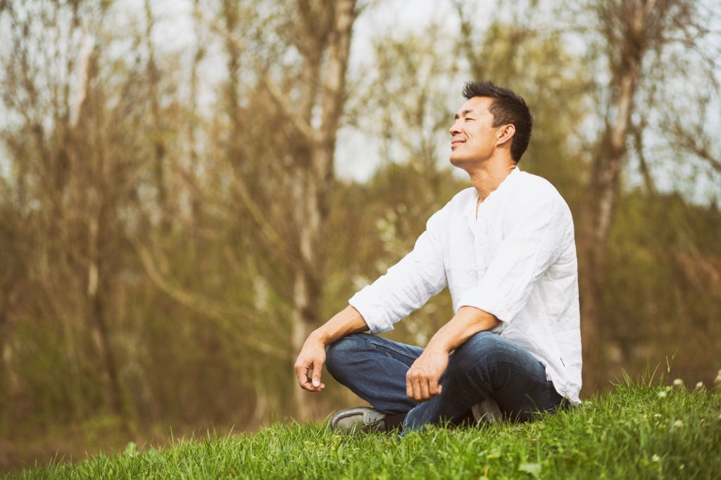 Mid-adult man enjoying the nature in Japan. Spring time with blossoming trees.